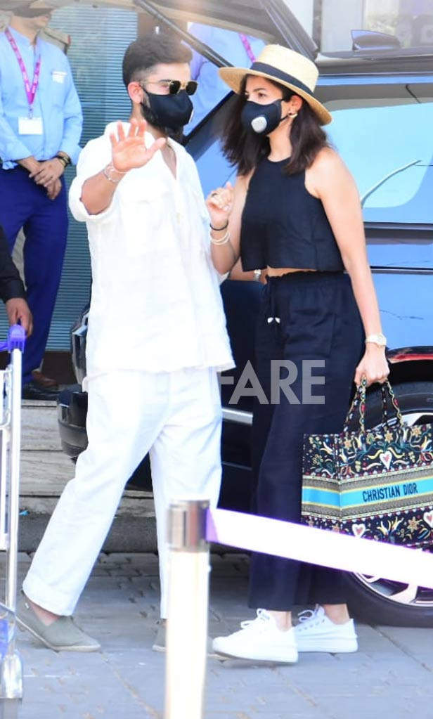 Anushka Sharma poses with Virat Kohli to the paparazzi at the Mumbai  airport Media